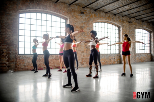 Group of women doing aerobics in group fitness studio working out together